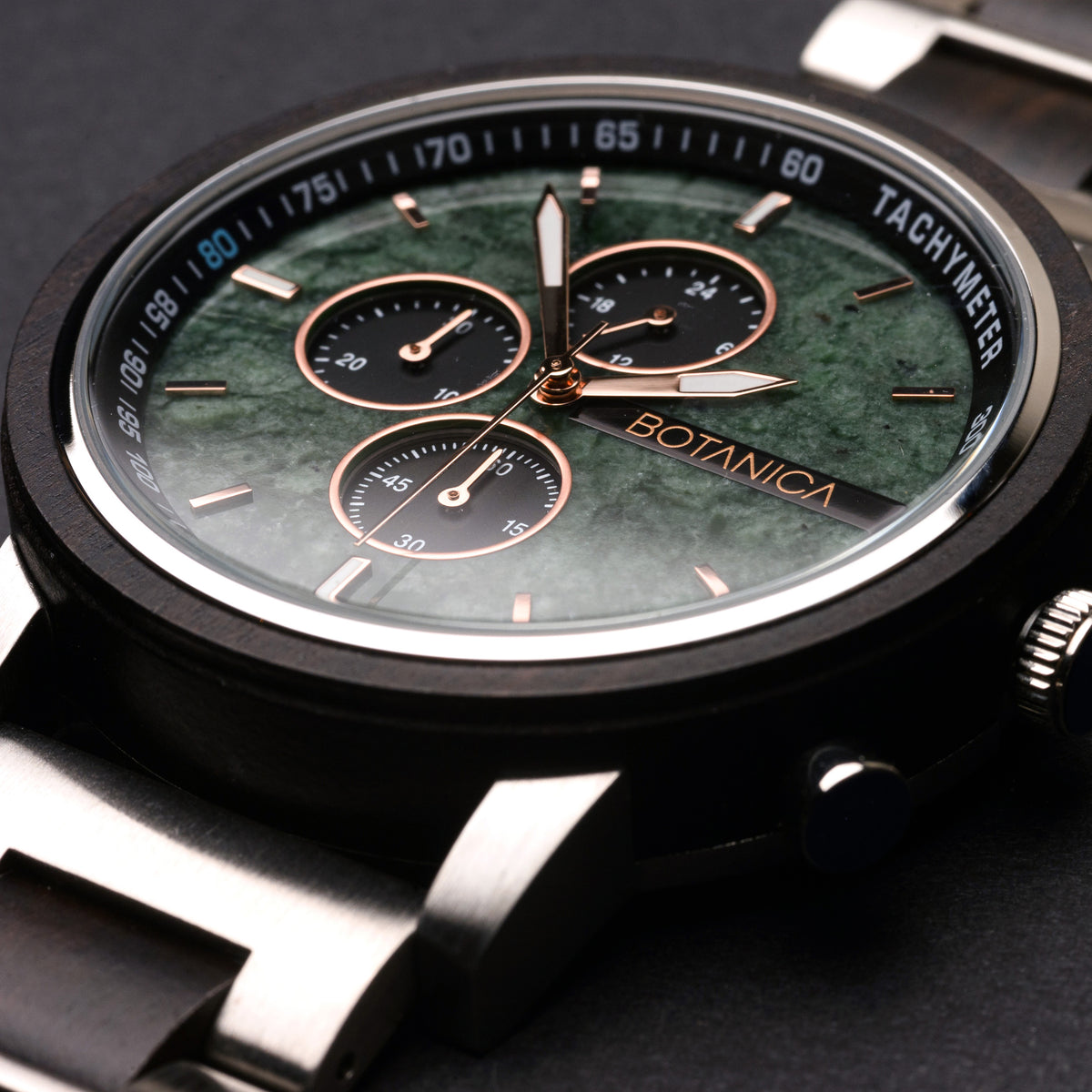 Close-up of a Botanica watch with a green stone face and black strap.