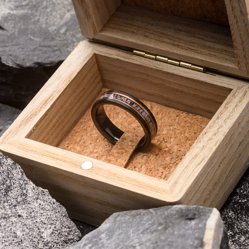 Wooden box with a ring on a natural stone background