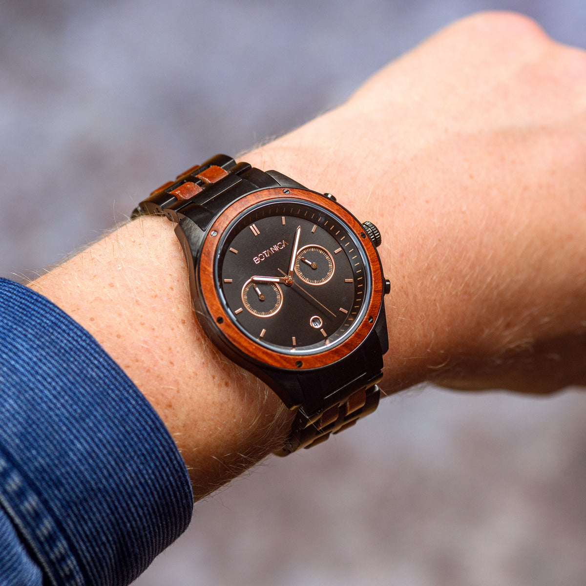A man wearing a Rosewood and Black Steel chronograph watch with 2 dials