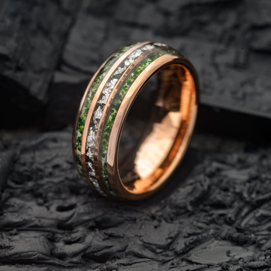 A Moss Agate triple groove and Rosegold Tungsten Ring resting on a charcoal base