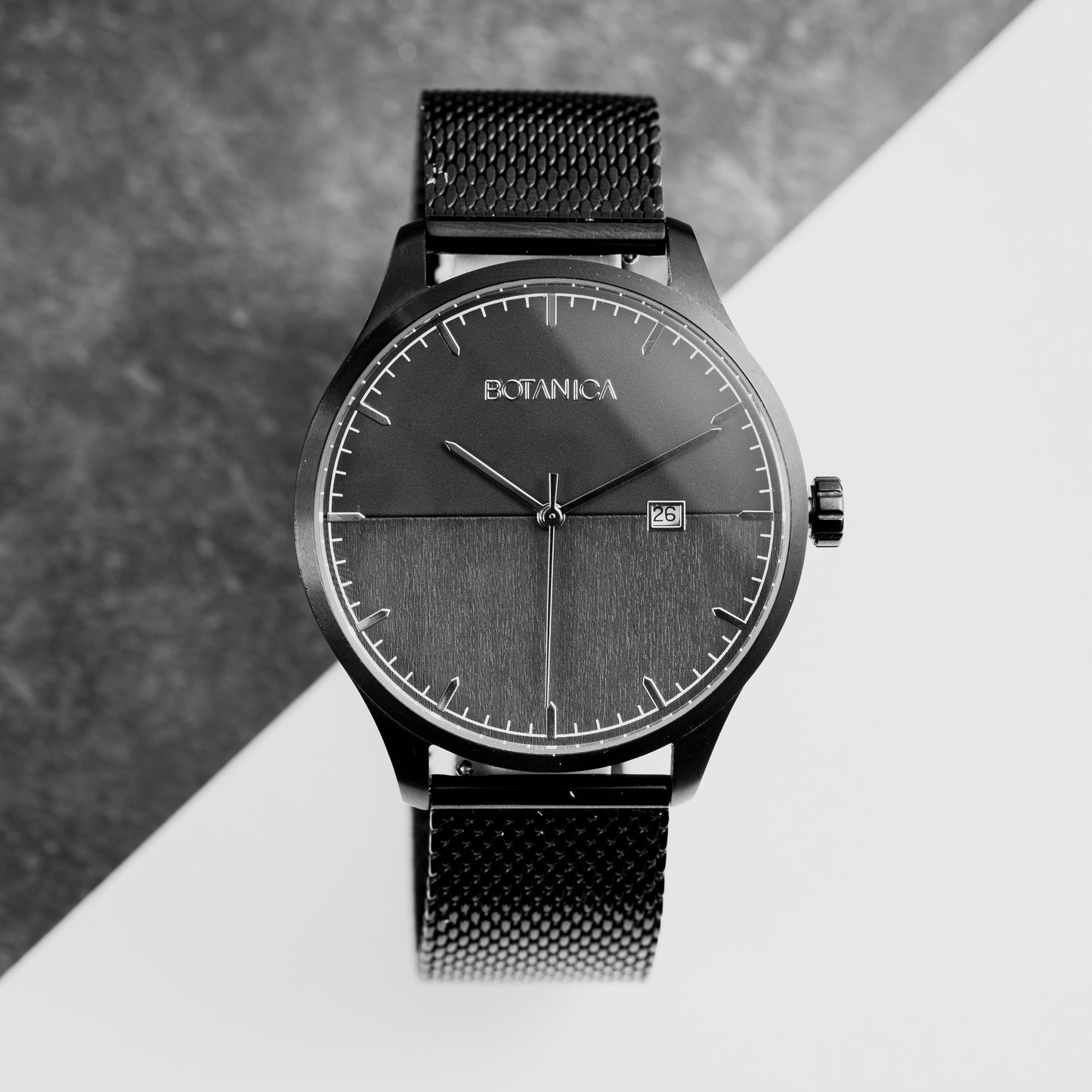 A black analog watch with a stainless steel band and a black sandalwood face, displayed against a grey background.