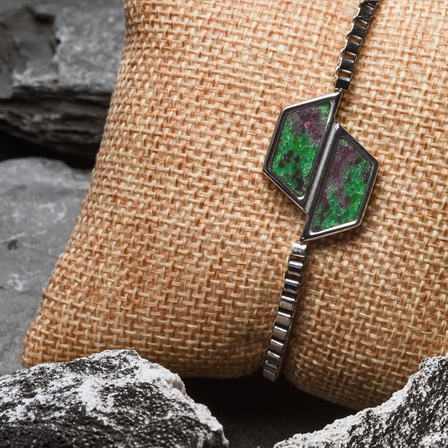 Bracelet with green gemstones on a textured surface