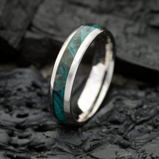 A 6mm Silver Tungsten Steel single groove ring with Canadian Maple inlay resting on a bed of Charcoal
