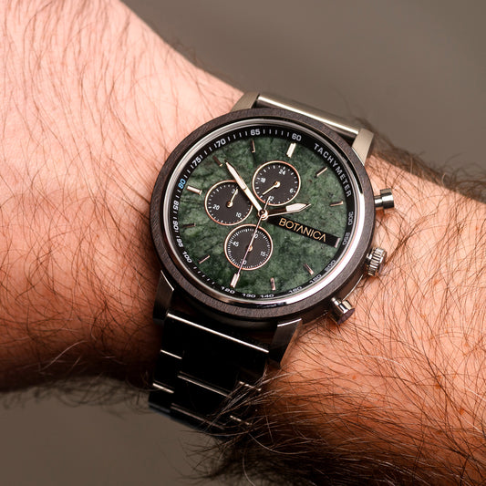 Close-up of a wrist wearing a Botanica watch with a green stone face.