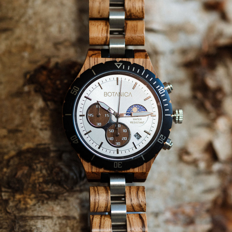 Wooden Watch with Black Bezel, silver face and walnut subdial design on a wood textured background