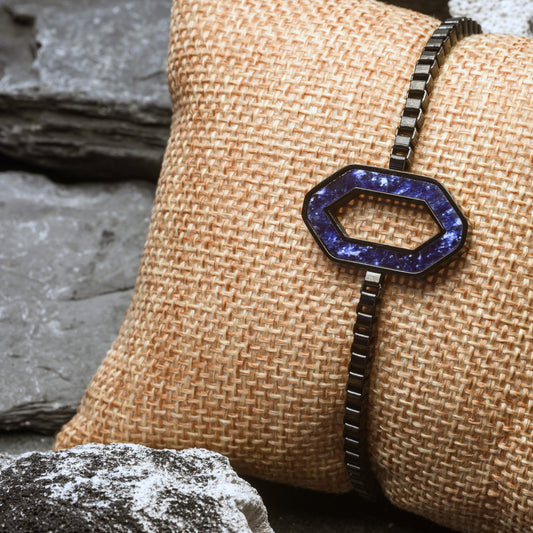 Bracelet with a Blue hexagonal pendant on a textured beige surface