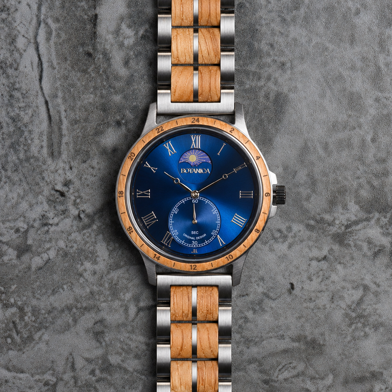 A Botanica men's watch featuring a blue sunburst dial, a bronze-toned bezel, and a dual-tone stainless steel and natural wood link bracelet, presented on a textured gray stone background.
