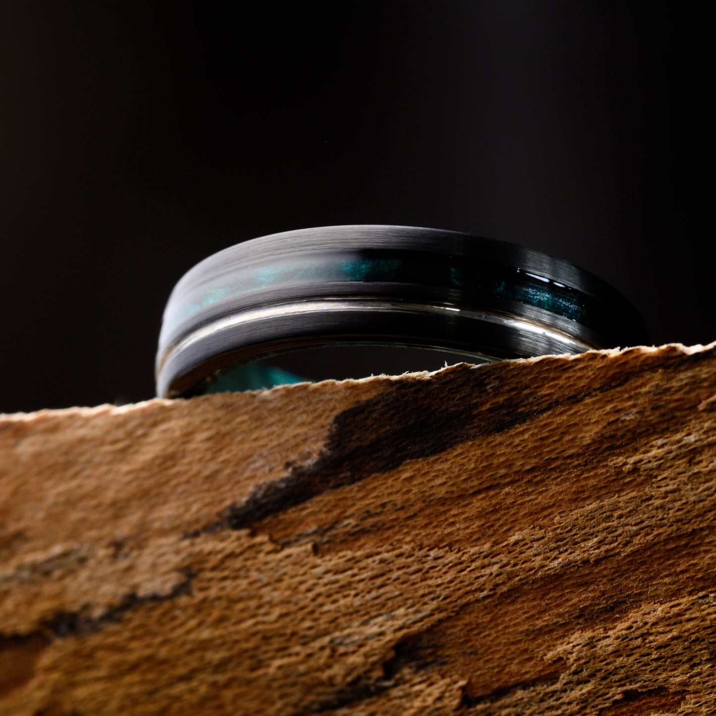 tungsten ring resting on a shelf with a blue inlay 