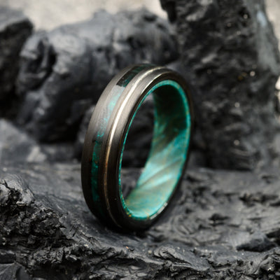 tungsten steel ring with blue maplewood inlay resting on stones for men or women