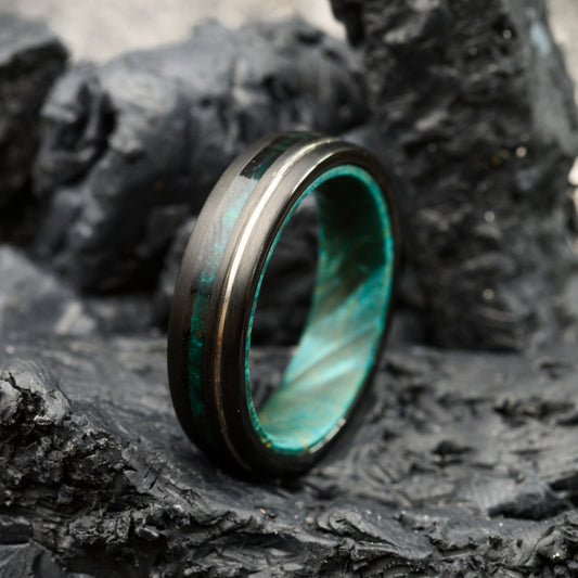 tungsten steel ring with blue maplewood inlay resting on stones for men or women