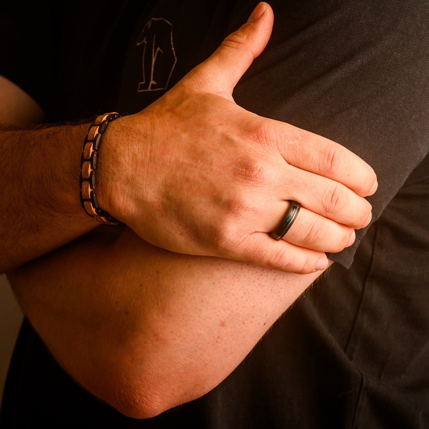 man holding arm wearing ring and bracelet 