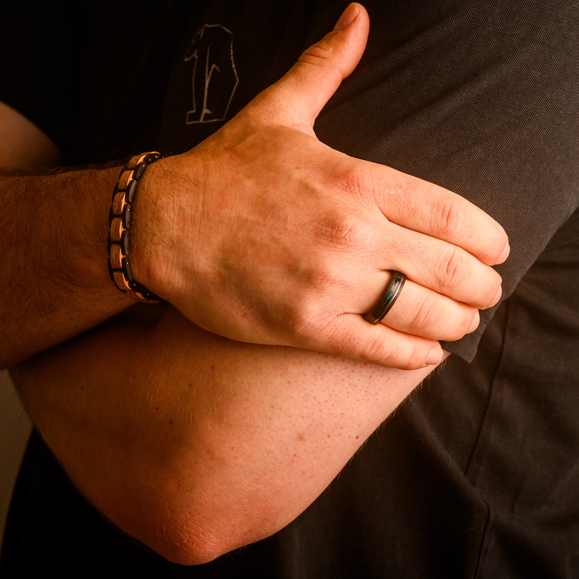 man holding arm wearing ring and bracelet 