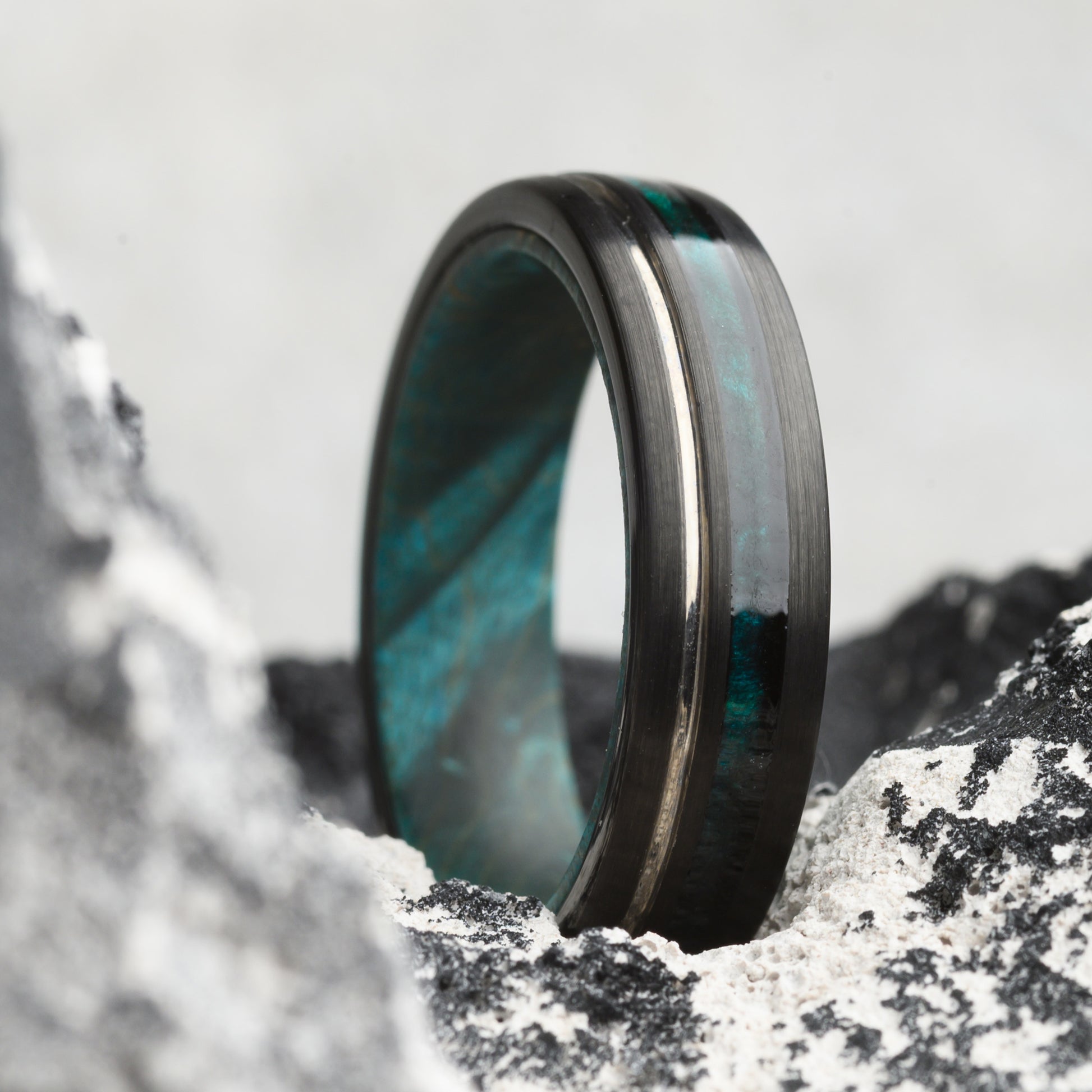 tungsten ring with maplewood inlay on rocky backdrop