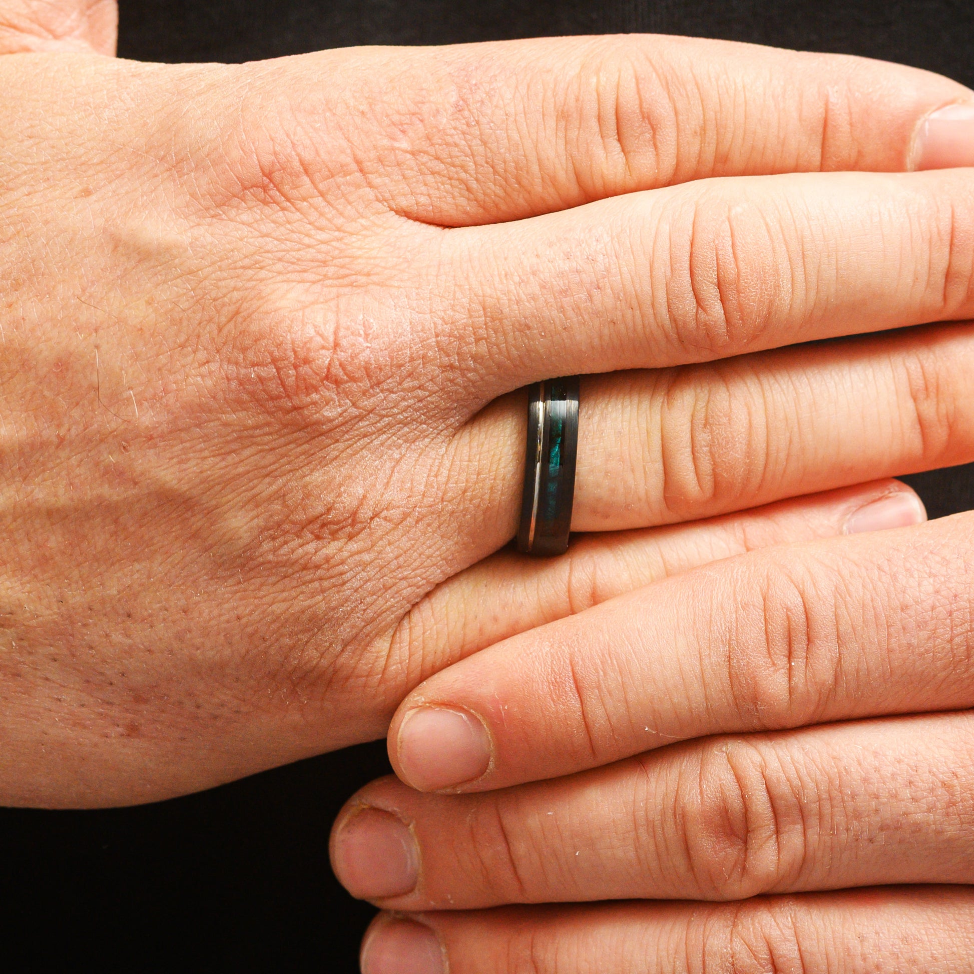 man wearing ring with blue inlay
