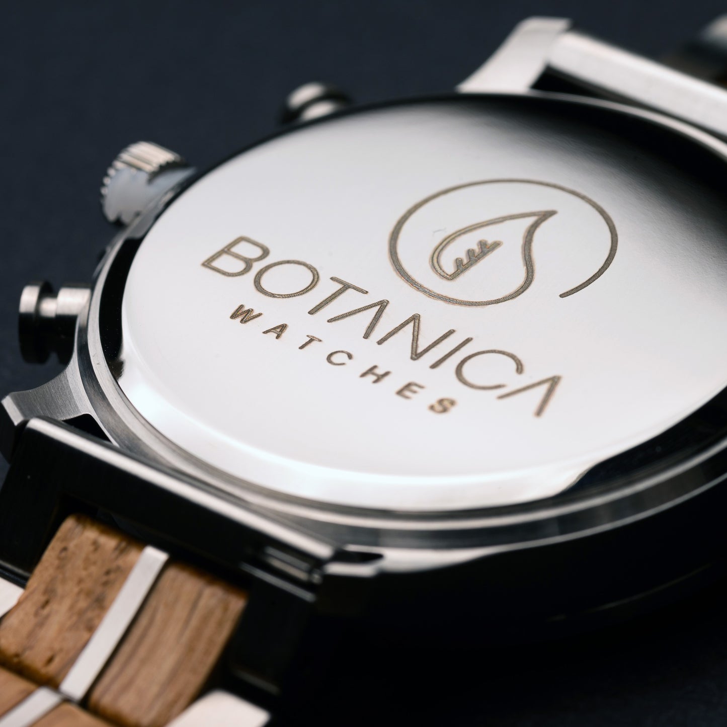 Close-up of a Botanica watch with wooden strap on a dark background