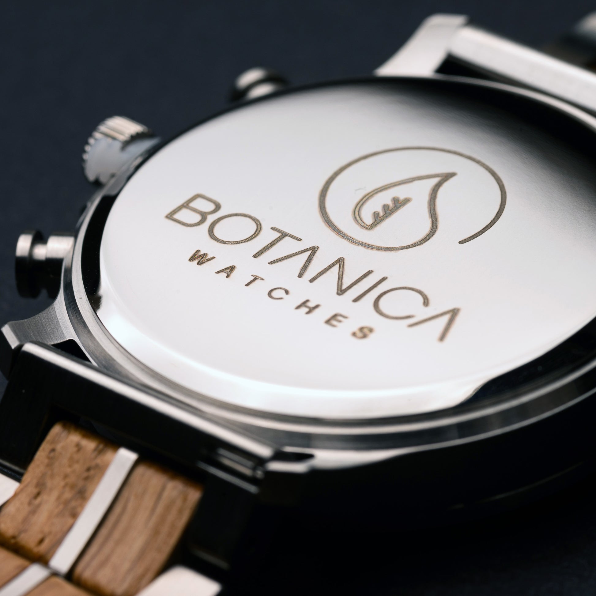 Close-up of a Botanica watch with wooden strap on a dark background