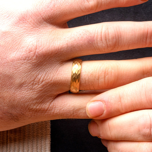 Gold ring on a finger with a neutral background