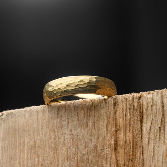 Gold ring on a wooden surface with a black background