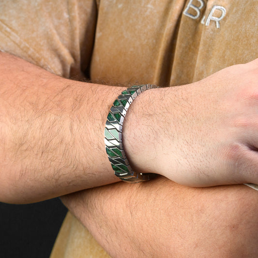 Close-up of a wrist wearing a green stone and silver bracelet.
