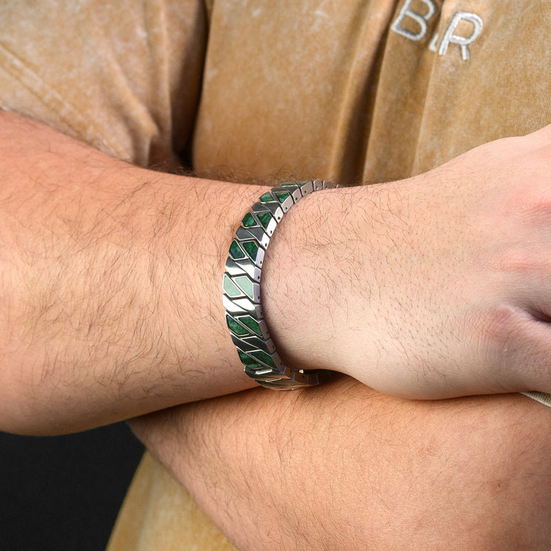 Close-up of a wrist wearing a green stone and silver bracelet.