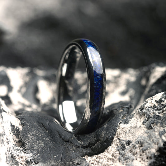 Silver ring with Lapis Stone Inlay on a textured stone surface with a blurred natural background