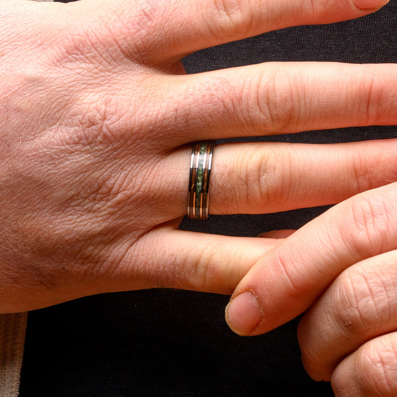 Hand wearing a ring with a black background