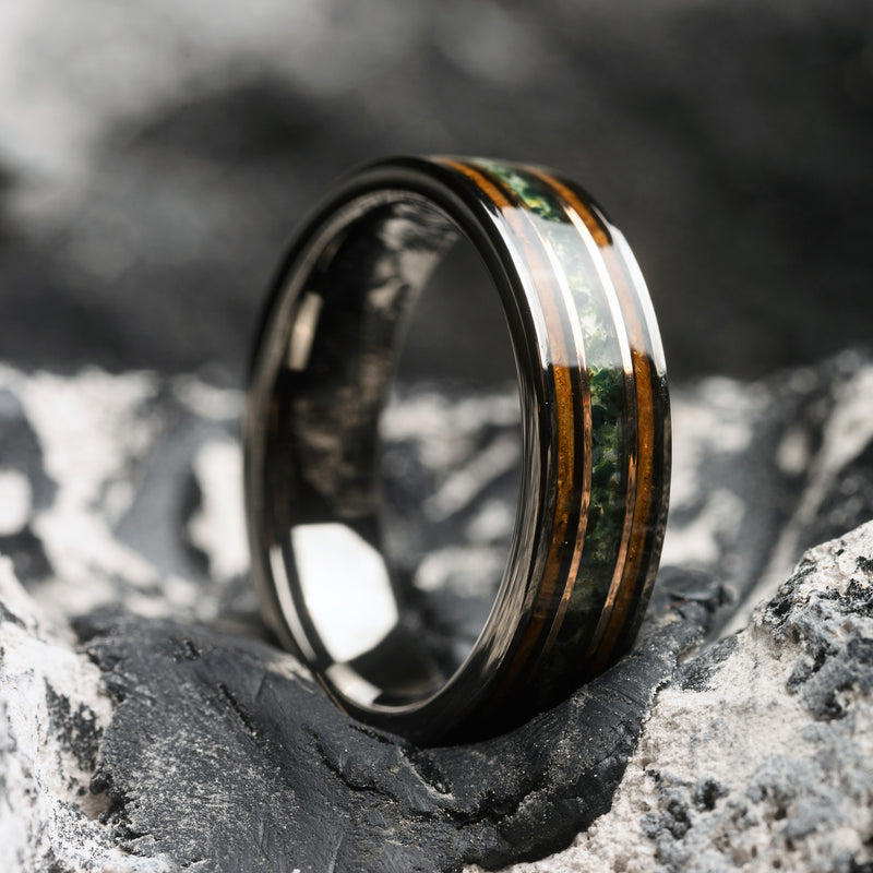 Wooden ring with black and gold accents on a textured surface