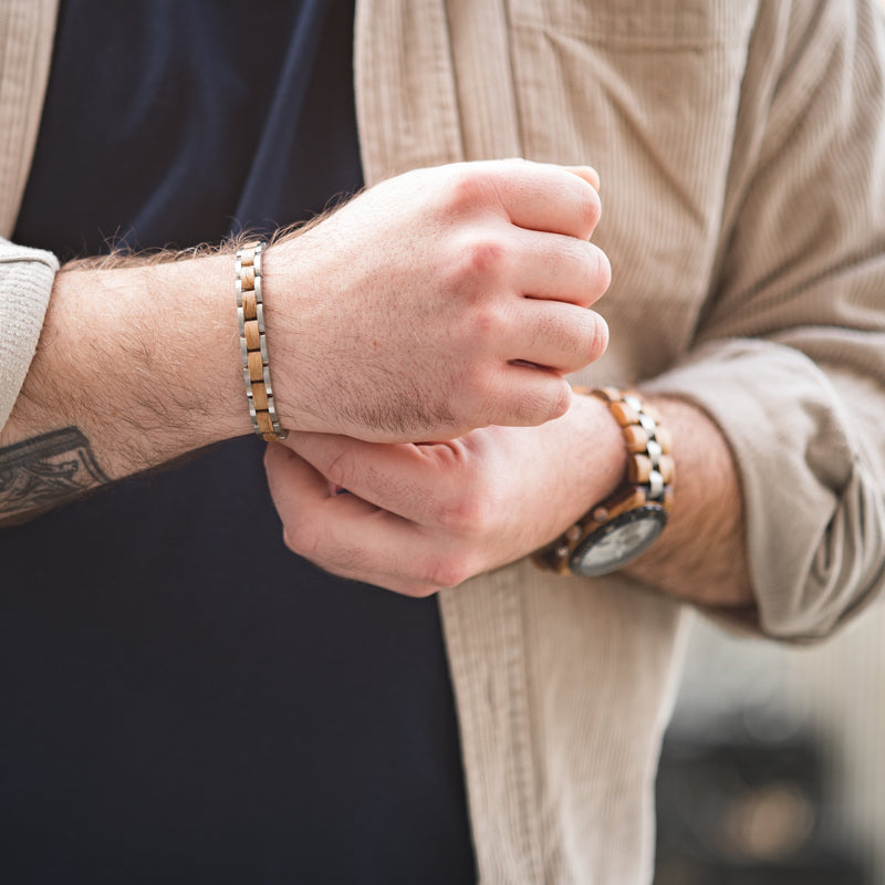A man wearing a silver and whiskey wood bracelet close up of the arm and wrist