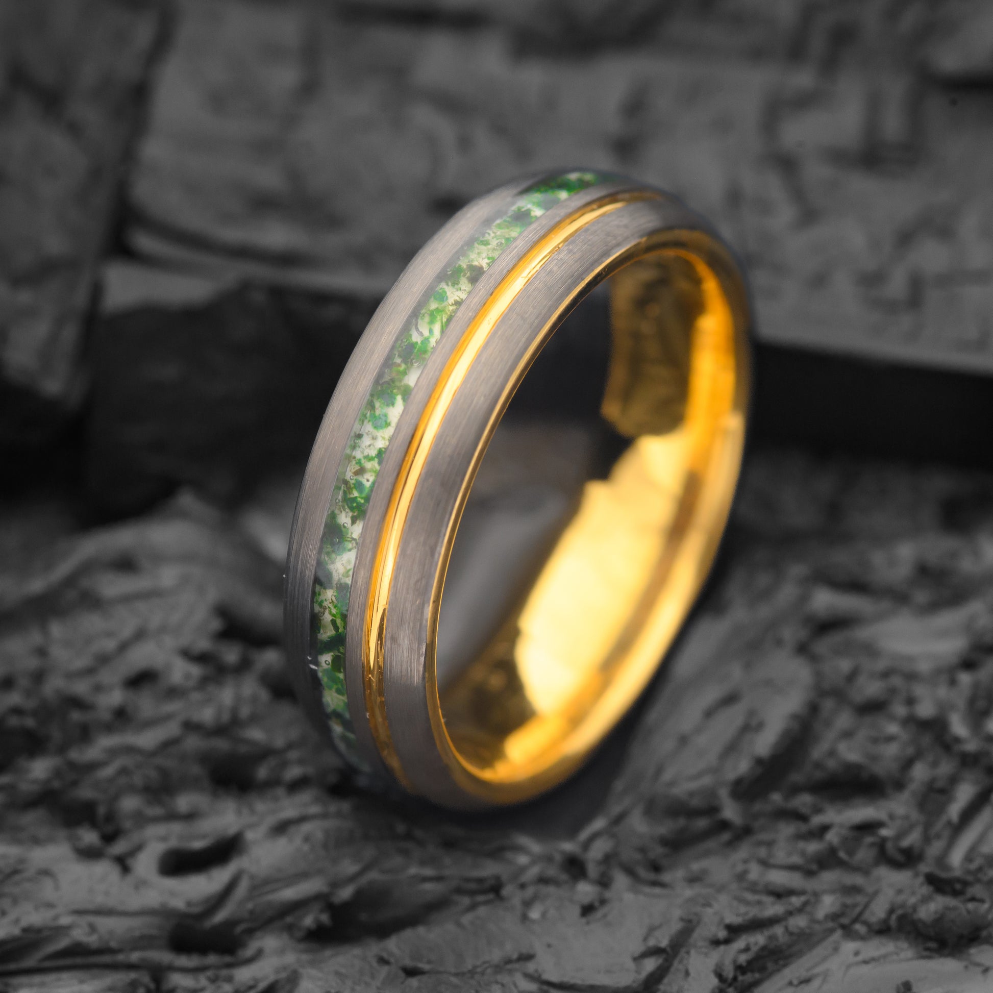 Moss Agate and Gold Band Tungsten Steel Ring resting on Charcoal