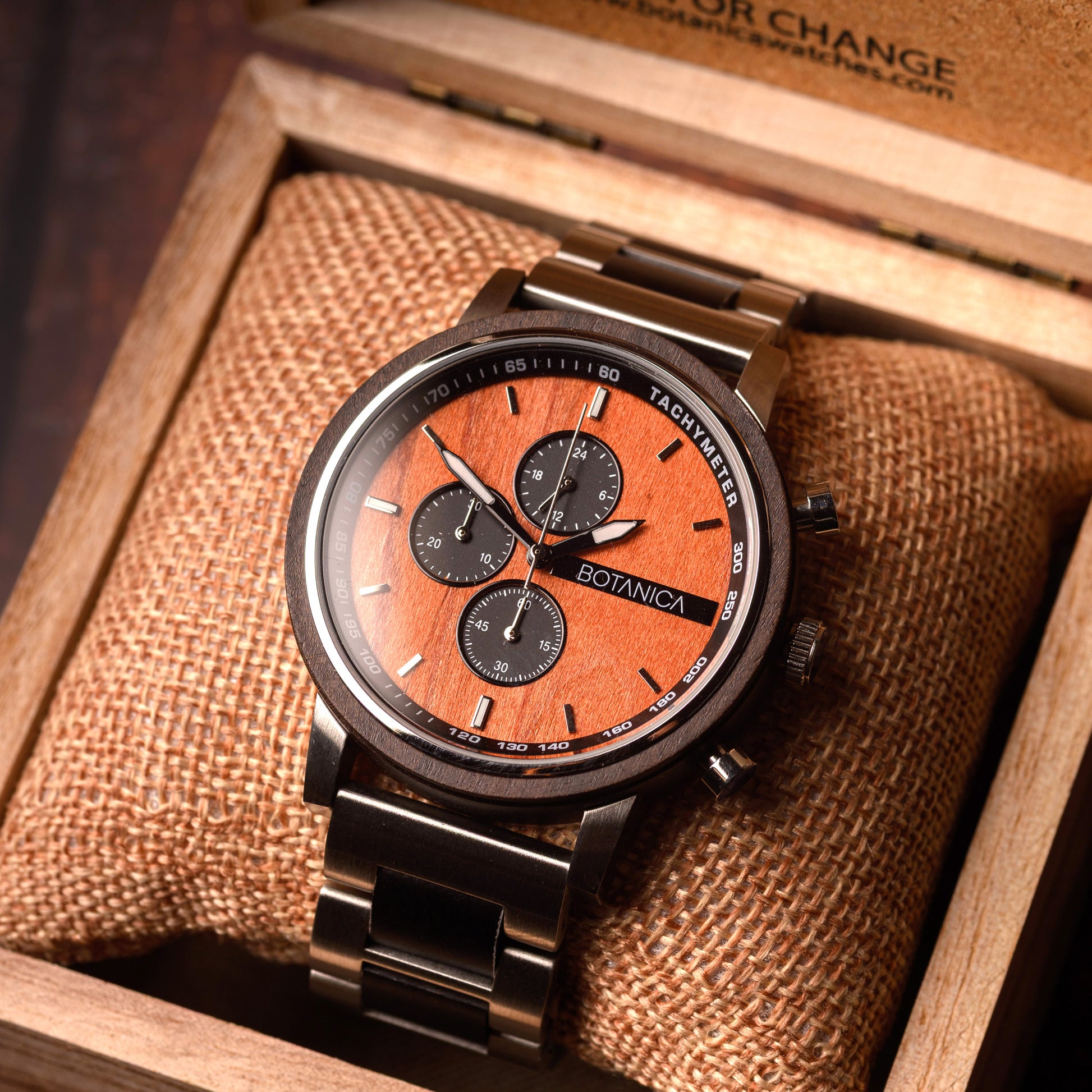 Wooden watch with brown face and black strap in a wooden box