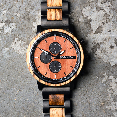 Wooden watch with black accents on a textured surface