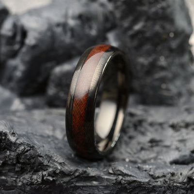 tungsten steel ring with rosewood band sitting on stone background for men or women
