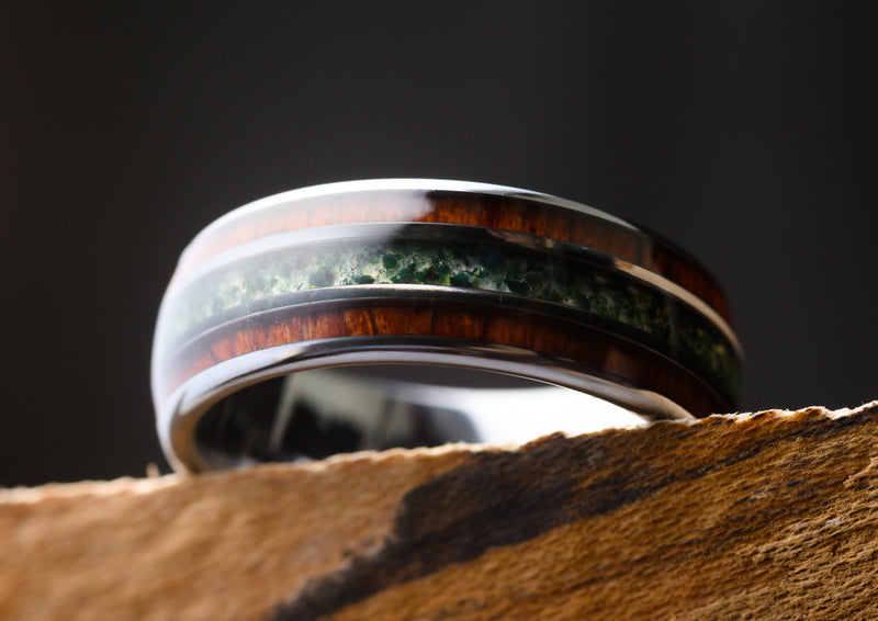 Wooden ring with moss agate and rosewood resting on shelf 