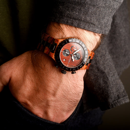 Close-up of a wrist wearing a wooden watch with a dark face.