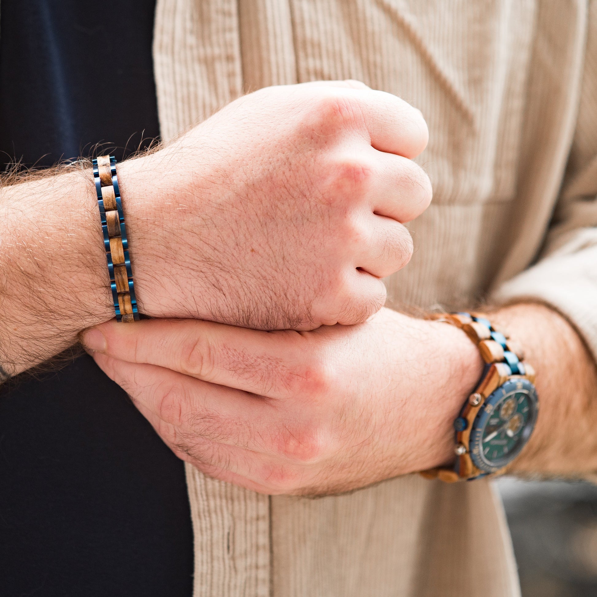 A man wearing a blue tungsten steel and zebrano wood bracelet with matching wooden watch