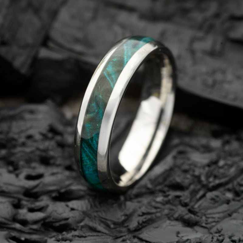 A 6mm Silver Tungsten Steel single groove ring with Canadian Maple inlay resting on a bed of Charcoal