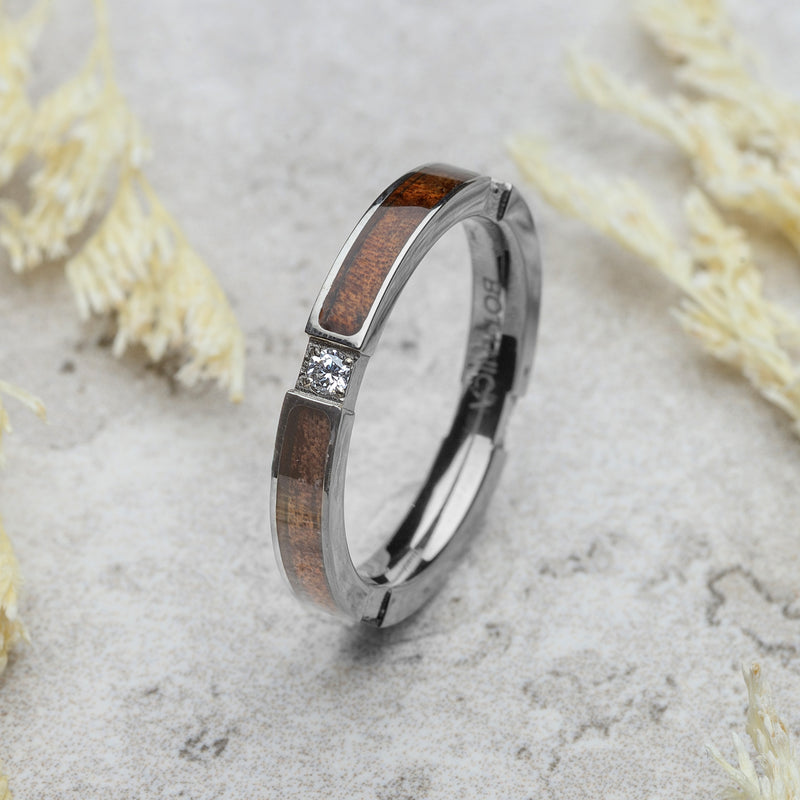 Silver ring with wooden inlay and diamond on a light background