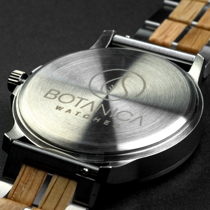 Close-up of a Botanica watch with wooden strap on a dark background