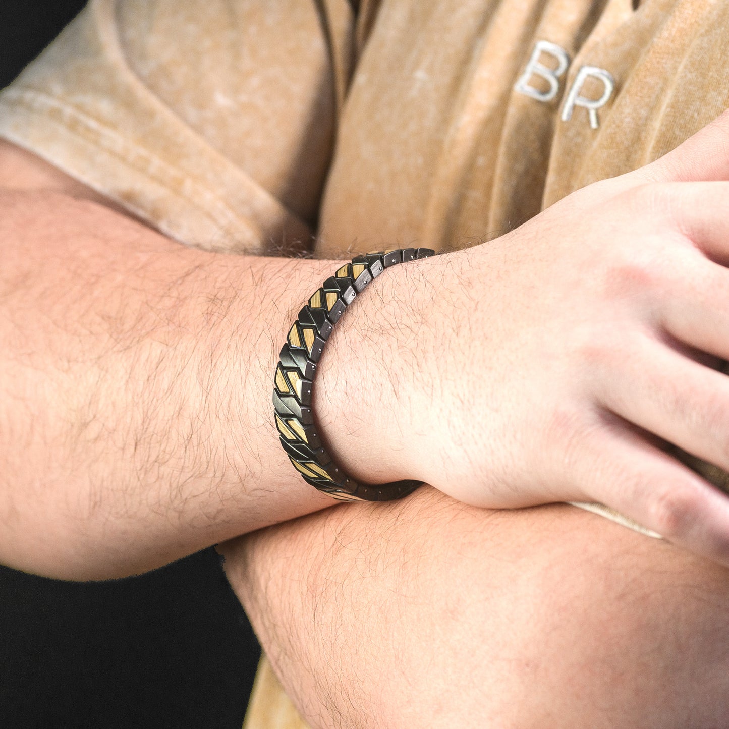 Person wearing a patterned bracelet on their wrist with a blurred background