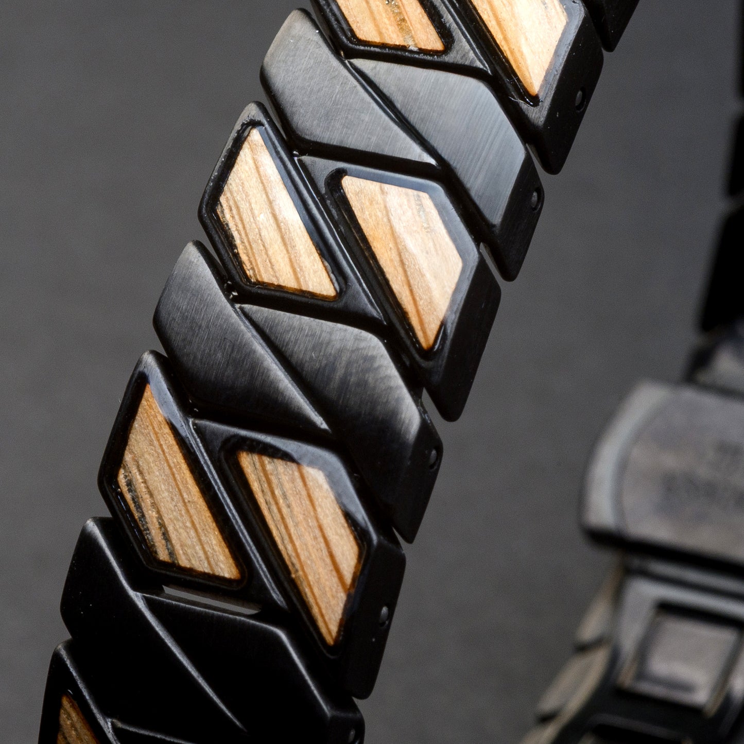 Close-up of a bracelet with black and wooden beads on a dark background