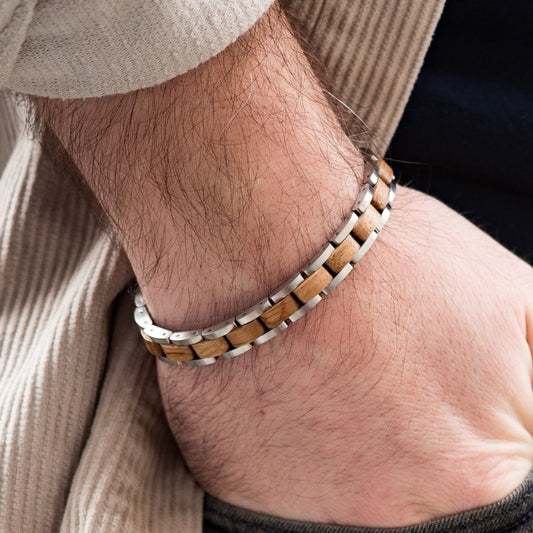 A man wearing a Silver tungsten steel bracelet with whiskey wood internal links.