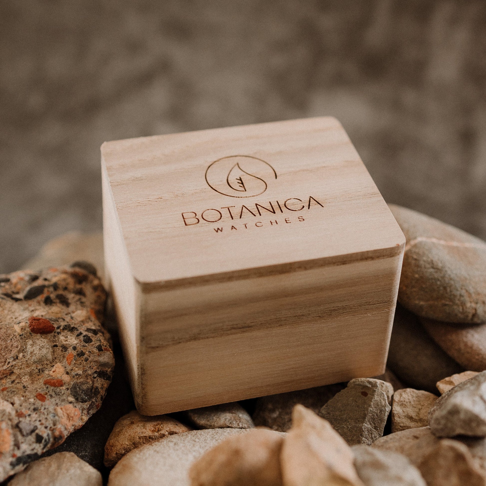 A Wooden Box closed sitting on a bed of stones