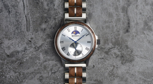 Wooden watch with silver face on a textured gray background