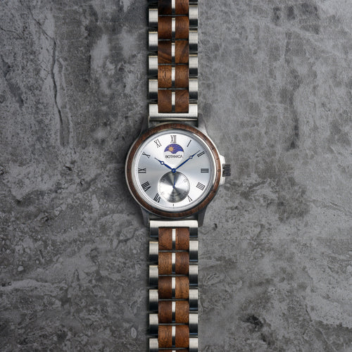 Wooden watch with silver case on a textured gray background